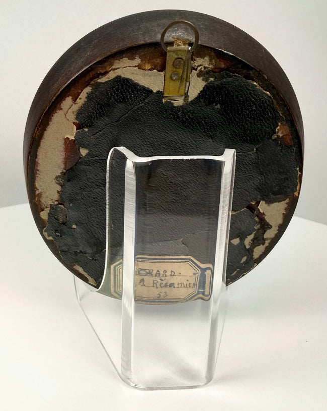 Back view of antique painted miniature frame showing brass hanging loop and handwritten label