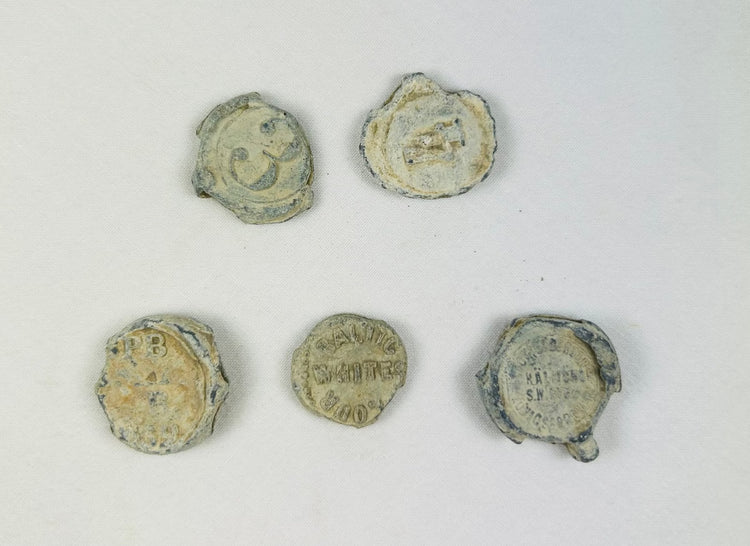 Marine-encrusted lead seals once used to identify bags and bales of traded goods