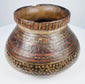 Close view of Mesoamerican polychrome pottery bowl with reddish-brown, dark and ochre painted patterns