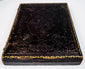 Closed mid-19th-century ambrotype case with deeply embossed floral and scroll decoration