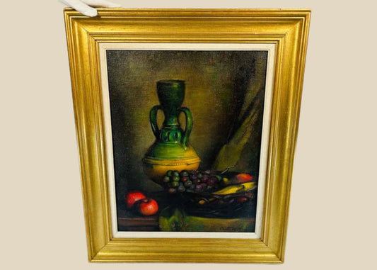 Mid-20th century still life oil painting depicting a green vase, grapes, and apples on a tabletop. Signed by the artist, framed in a gilded wooden frame, with rich colors and detailed brushwork.
