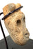 Close-up of porous bone grain and deep hollow eye cavity on pre-Columbian mask pendant