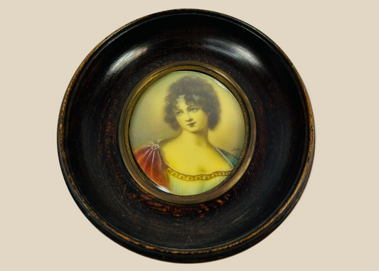 Late 19th–early 20th-century French miniature portrait of Madame Juliette Récamier, bust-length in Empire-style gown with jeweled trim and gauzy wrap, watercolor/gouache on ivorine under convex glass, in original turned ebonized wood frame with brass bezel, after François Gérard, circa 1890–1910.