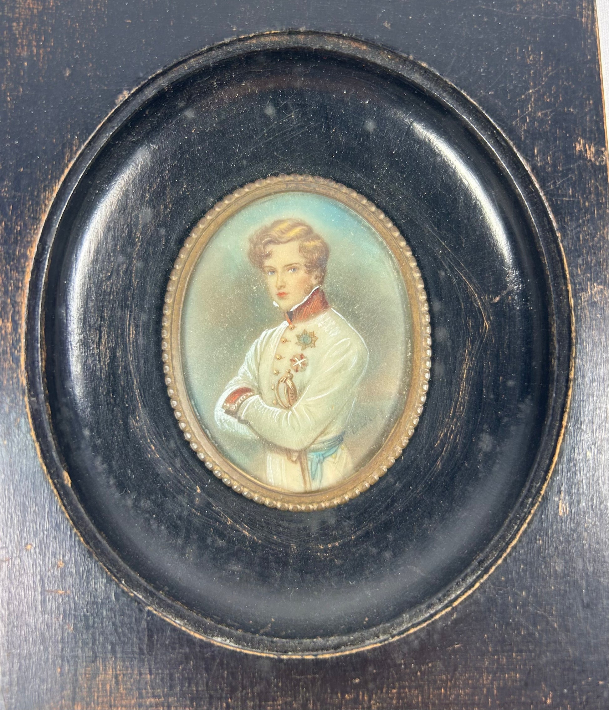 Finely painted mid–late 19th-century miniature portrait of Napoleon II, Duke of Reichstadt, in Austrian white dress uniform with red collar and blue sash, gouache on wafer under glass, set in original ebonized wood frame with brass bezel, Central Europe, circa 1860–1885