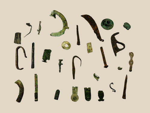 Collection of 28 ancient Roman bronze artifacts including amulets, handles, buttons, and decorative items, showing patina and wear, spanning 1st–12th century AD across Europe, North Africa, and the Near East.