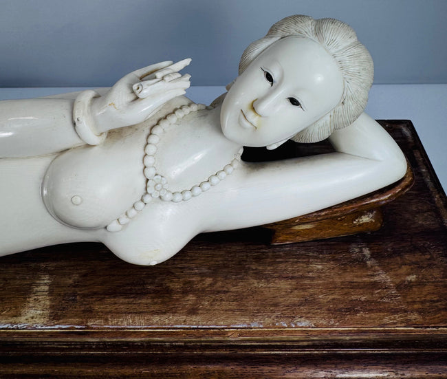 Close-up of the carved beaded necklace, bracelets and decorative details on the reclining figure