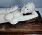 Close-up of the carved beaded necklace, bracelets and decorative details on the reclining figure