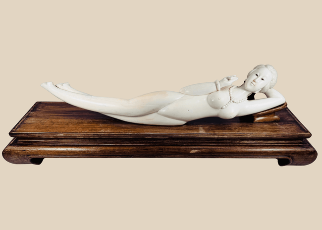 Monumental Chinese doctor’s lady-style reclining sculpture with carved jewellery, pointed footwear and fitted hardwood pedestal