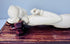 Front view of the reclining female figure showing her raised arm, carved jewellery and elongated pose