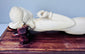 Front view of the reclining female figure showing her raised arm, carved jewellery and elongated pose