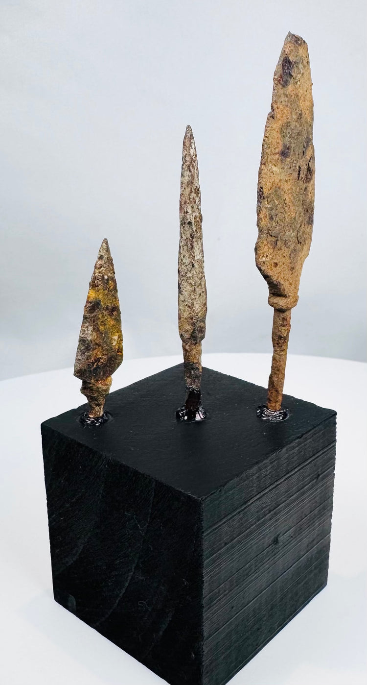 Small triangular iron arrowhead with short tang and mineral encrustation
