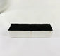 Authentic NASA Space Shuttle Thermal Protection System (TPS) tile from the 1980s, made of silica-based ceramic with black Reaction Cured Glass coating, used for reentry heat resistance, preserved in NASA-issued display case.