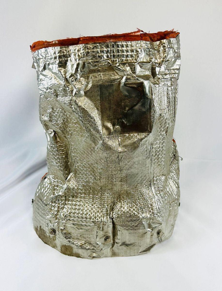 Flown NASA Space Shuttle insulation panel made of fibrous silica batting, stamped April 1983 with serial number and manufacturer code, used in shuttle thermal protection system, approximately 11 x 10 inches.