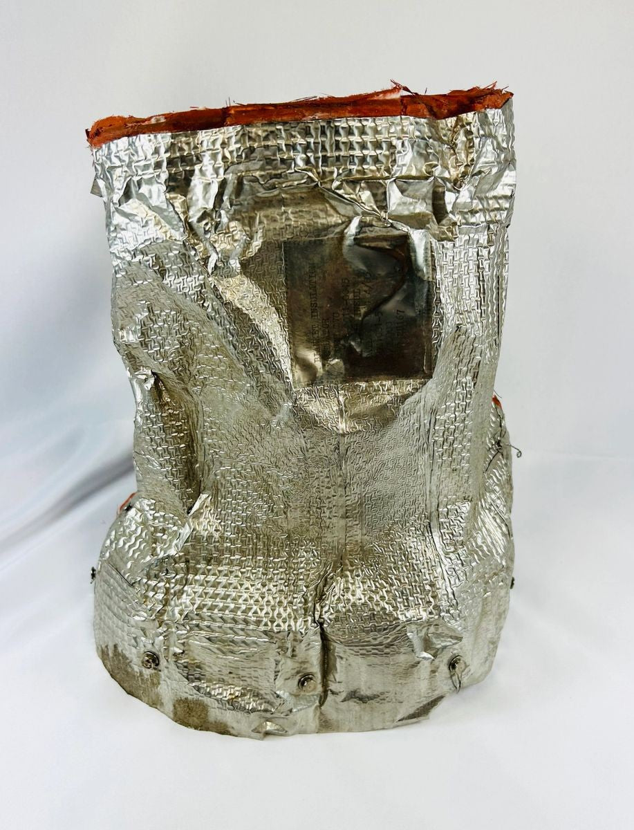 Flown NASA Space Shuttle insulation panel made of fibrous silica batting, stamped April 1983 with serial number and manufacturer code, used in shuttle thermal protection system, approximately 11 x 10 inches.