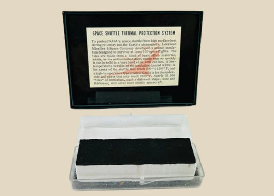 Authentic NASA Space Shuttle HRSI tile from the 1980s, silica-based ceramic with black Reaction Cured Glass (RCG) coating, designed for high-temperature reentry, displayed in original NASA-issued case with documentation.