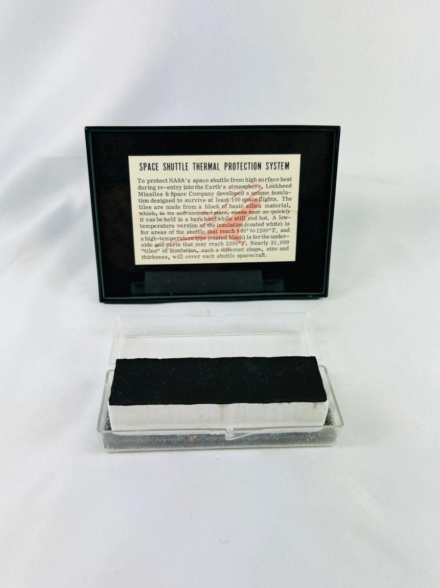 Authentic NASA Space Shuttle HRSI tile from the 1980s, silica-based ceramic with black Reaction Cured Glass (RCG) coating, designed for high-temperature reentry, displayed in original NASA-issued case with documentation.