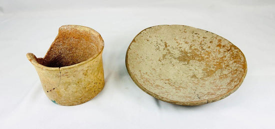 Set of Neolithic terracotta pottery, including a shallow bowl and cylindrical vessel fragment, circa 4000–2000 BCE, with natural earthy tones, unglazed surfaces, and aged patina.