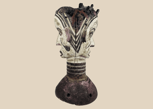 Nigerian Igbo Janus dance crest featuring opposing carved faces, painted decoration, and ceremonial masquerade symbolism.