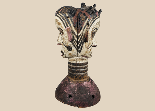 Nigerian Igbo Janus dance crest featuring opposing carved faces, painted decoration, and ceremonial masquerade symbolism.