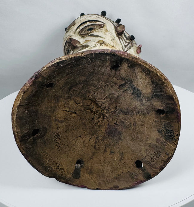 Carved wooden Nigerian Janus dance crest displaying ancestral symbolism, painted details, and ceremonial craftsmanship.