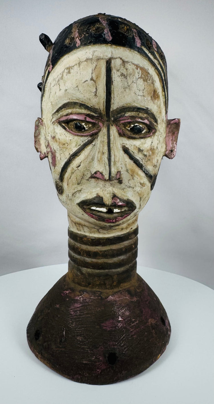 Nigerian Igbo ceremonial crest with dual-faced human forms and traces of original pigment decoration.