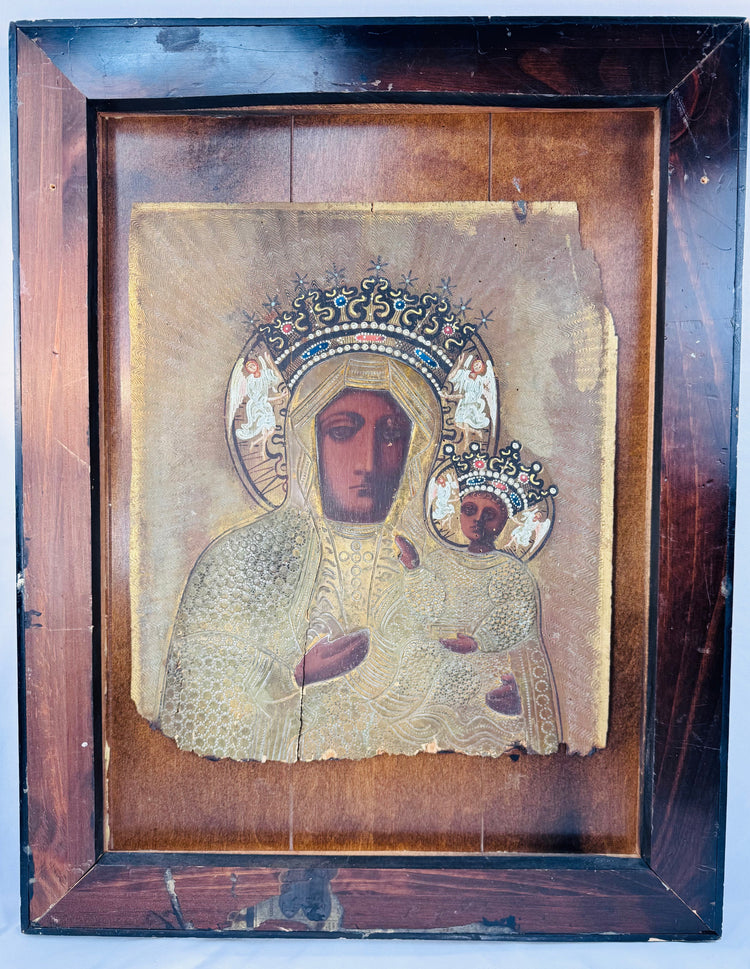 Antique icon of Our Lady of Częstochowa with painted faces, gilded details, and elaborate metal covering.