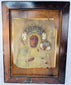 Black Madonna devotional icon with embossed metal revetment, jeweled crowns, and decorative halo motifs.