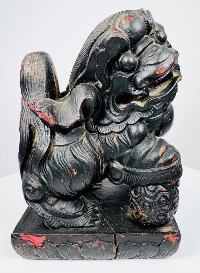 Close-up of individual Chinese guardian lion with fierce expression, exposed teeth, stylized mane and red pigment traces
