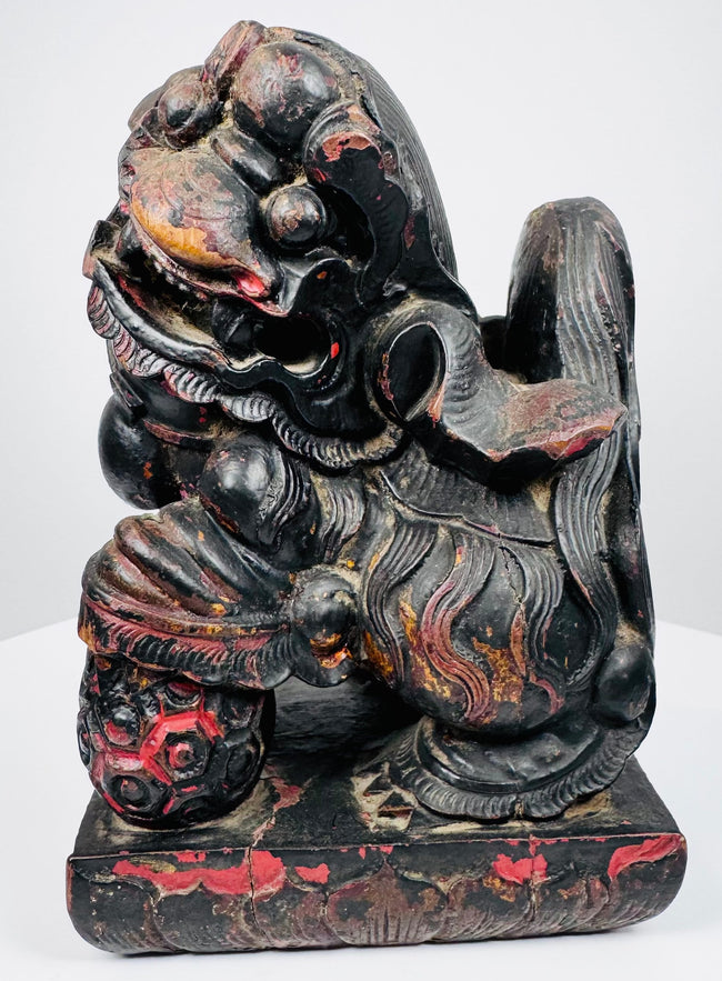 Rear view of matched Chinese guardian lions showing sculpted tails, lacquered wood construction and integral rectangular bases