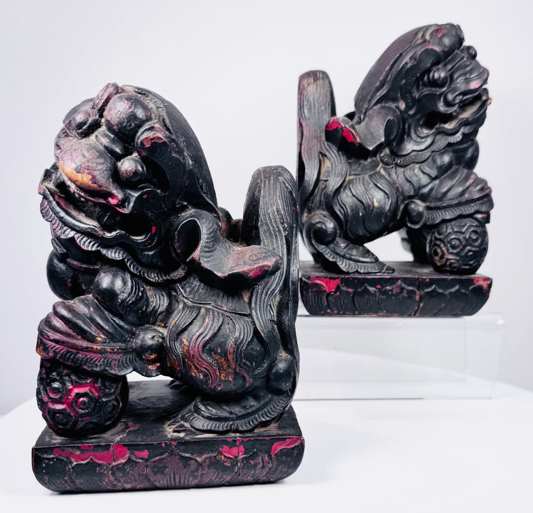 Front view of matched Chinese guardian lions showing open mouths, bulging eyes, carved manes and lotus-patterned bases