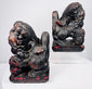 Antique Chinese Foo dog pair in mirrored poses with raised paws resting on patterned brocade balls