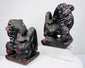 Side view of antique Chinese wooden guardian lion pair displaying raised tails, muscular bodies and deeply carved manes