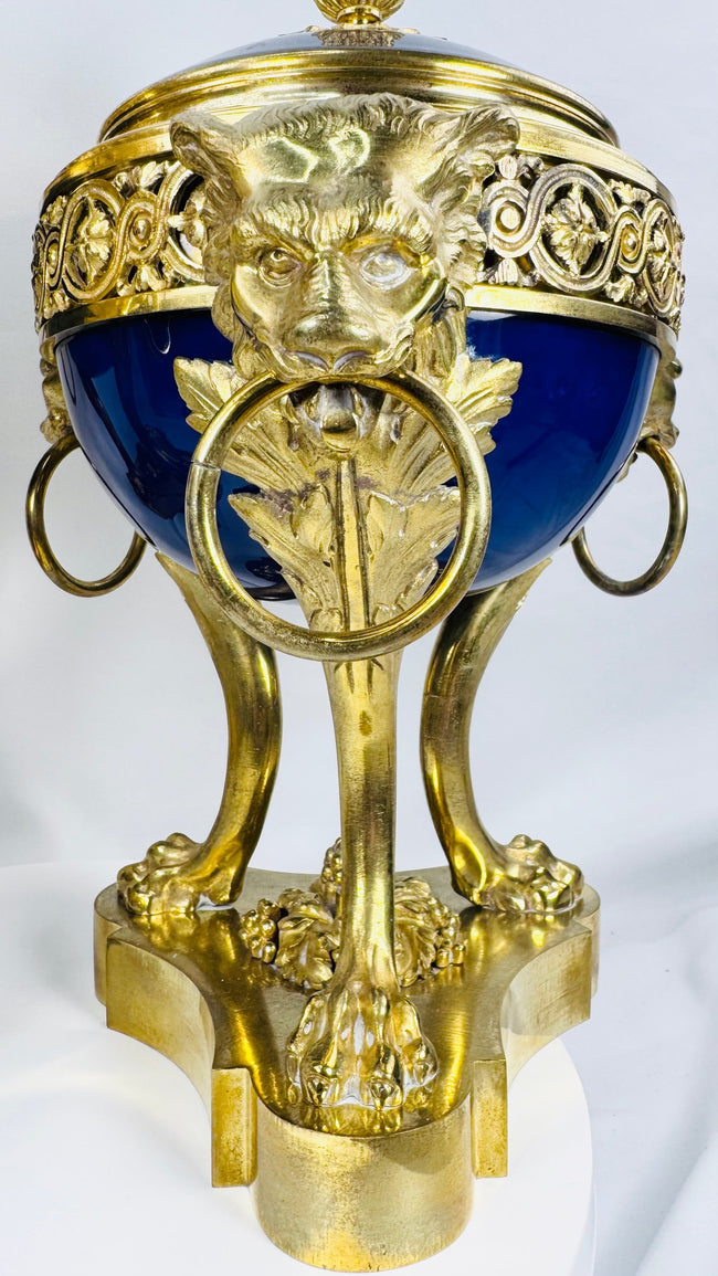 Decorative French ormolu and porcelain vase with openwork gallery, pinecone finial, and Classical design elements.