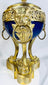 Decorative French ormolu and porcelain vase with openwork gallery, pinecone finial, and Classical design elements.