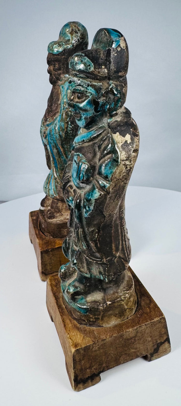Antique Asian pottery figure pair displaying turquoise glaze loss and surface craquelure