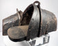 Close-up of hand-forged iron stirrup with suspension loop, rivets and aged leather lining