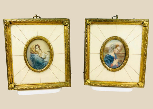 Pair of 19th century hand-painted miniature portraits in gilt frames with ivory-style panel insets. Depicting devotional female figures, one in prayer and one cradling a child. Original rectangular frames with oval portrait centers, fine detail and patina.