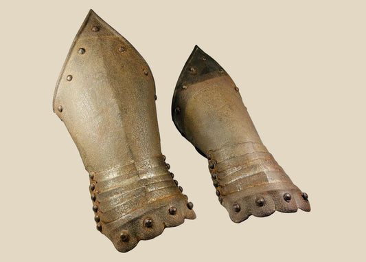 pair of Gothic-style steel gauntlets, likely 16th–17th century style, featuring riveted plates, flared cuffs, and subtle etched detailing; aged patina and hand-forged construction evoke authentic European medieval armor craftsmanship, once used for hand and wrist protection in battle or ceremonial display.