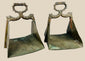 Antique pair of heavy brass equestrian stirrups with triangular footrests and intricately cast serpent motifs forming the handles, exhibiting detailed craftsmanship, natural patina, and symbolic protective design elements often associated with strength and guardianship in traditional horsemanship.