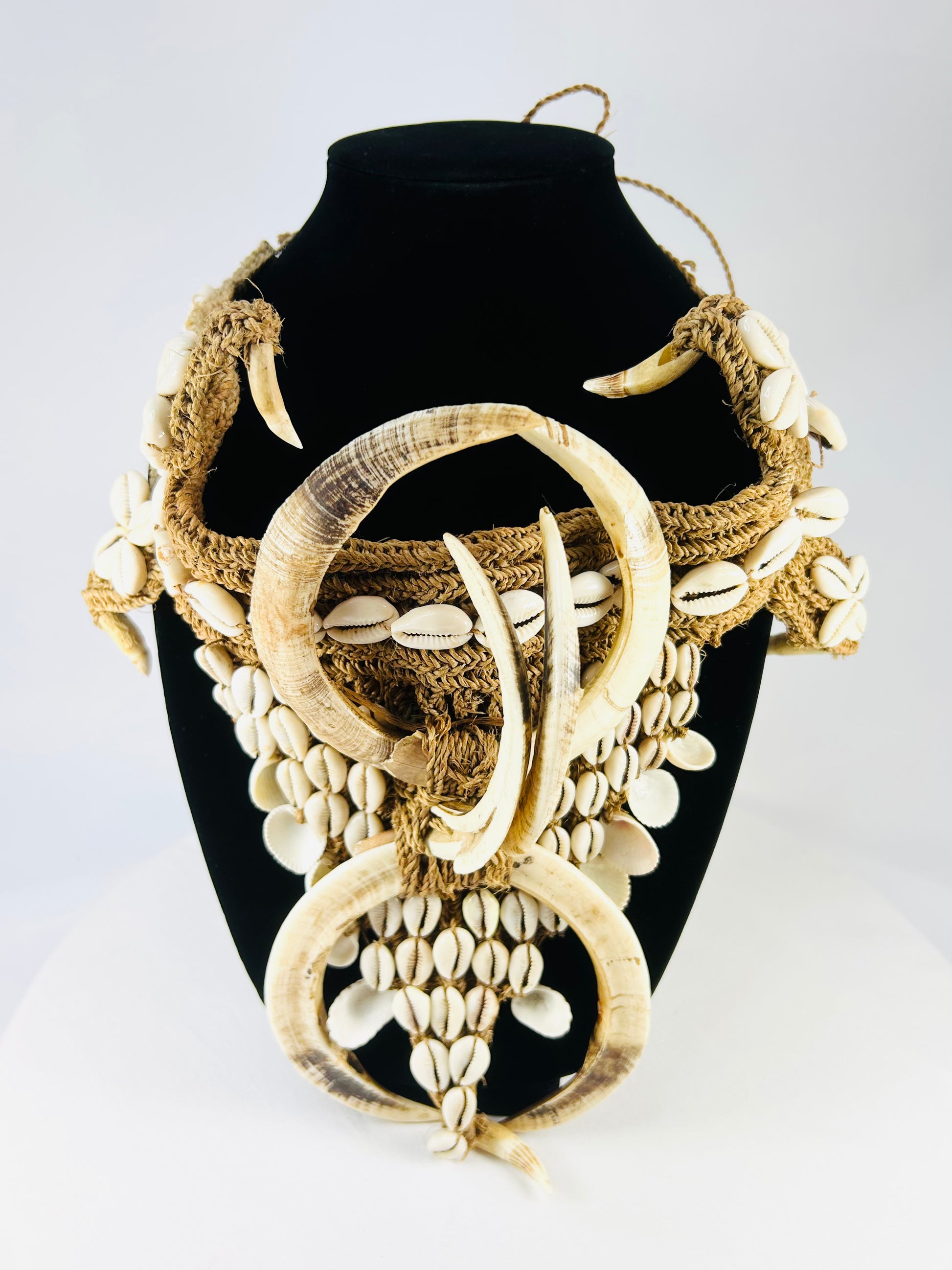Early 20th century Papua New Guinea ceremonial apron, featuring boar tusks, cowrie shells, and natural fiber bindings, used in tribal initiations and dances, ethnographic Melanesian artifact