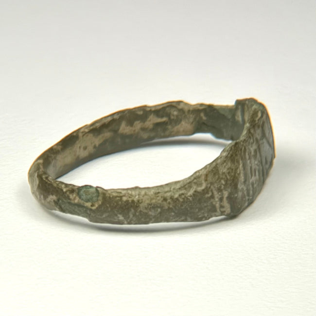 Rear view of ancient Roman bronze finger ring with irregular archaeological surface and surviving patina