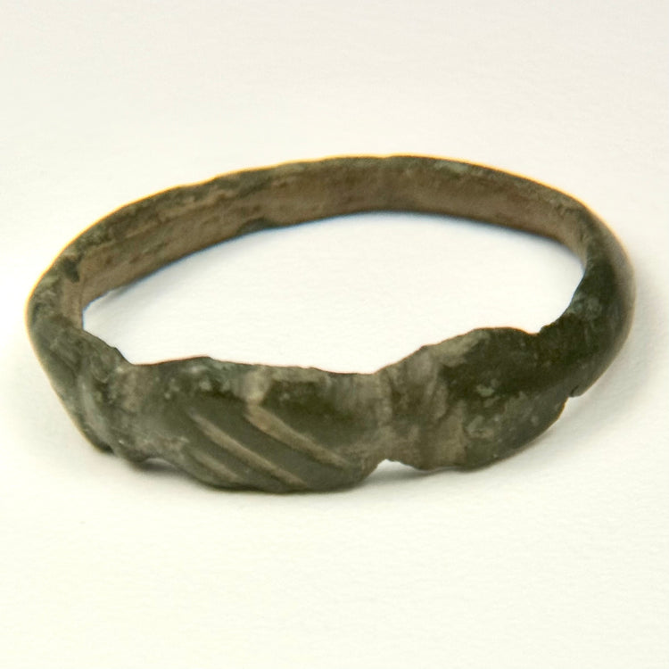 Late Antique bronze finger ring with solid cast hoop, expanding shoulders, and geometric incisions