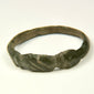 Side view of Late Roman bronze ring showing geometric shoulder grooves and worn archaeological surface