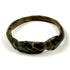 Close-up of ancient bronze ring showing engraved linear bezel, oxidation, and mineralized surface