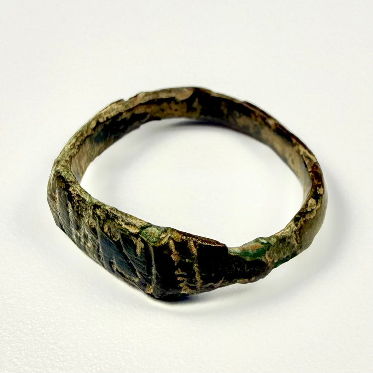 Roman Imperial bronze finger ring showing vertical grooves, diagonal incisions, and mineral deposits