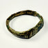 Ancient Roman bronze jewelry with engraved geometric face, angular band, oxidation, and earthen encrustation