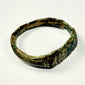 Ancient Roman bronze jewelry with engraved geometric face, angular band, oxidation, and earthen encrustation