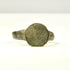 Side profile of ancient bronze finger ring with raised circular bezel and narrowing hoop, Eastern Mediterranean origin
