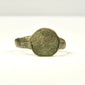 Side profile of ancient bronze finger ring with raised circular bezel and narrowing hoop, Eastern Mediterranean origin