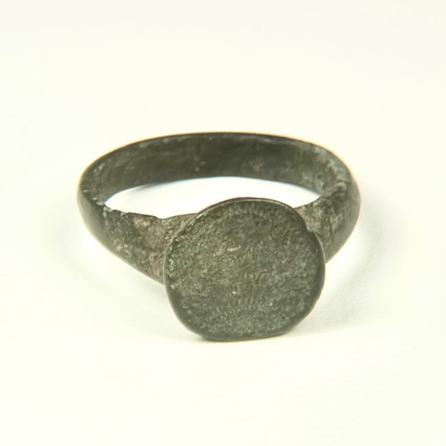 Roman to Early Byzantine bronze ring, US size 8, with broad circular bezel and intact tapered hoop, circa 1st–8th century CE